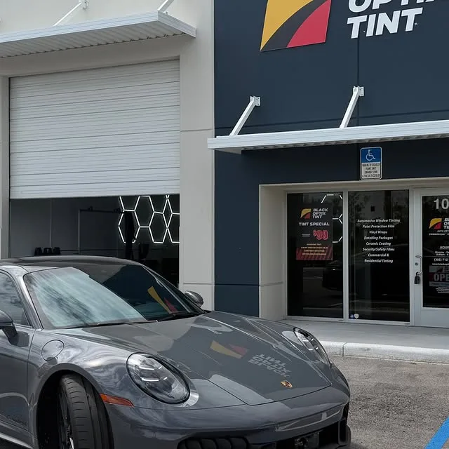 Grey Porsche 911 in front of Black Optix Tint Doral