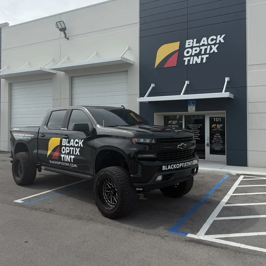 Black Optix Tint wrapped Chevy Silverado parked outside the Doral shop